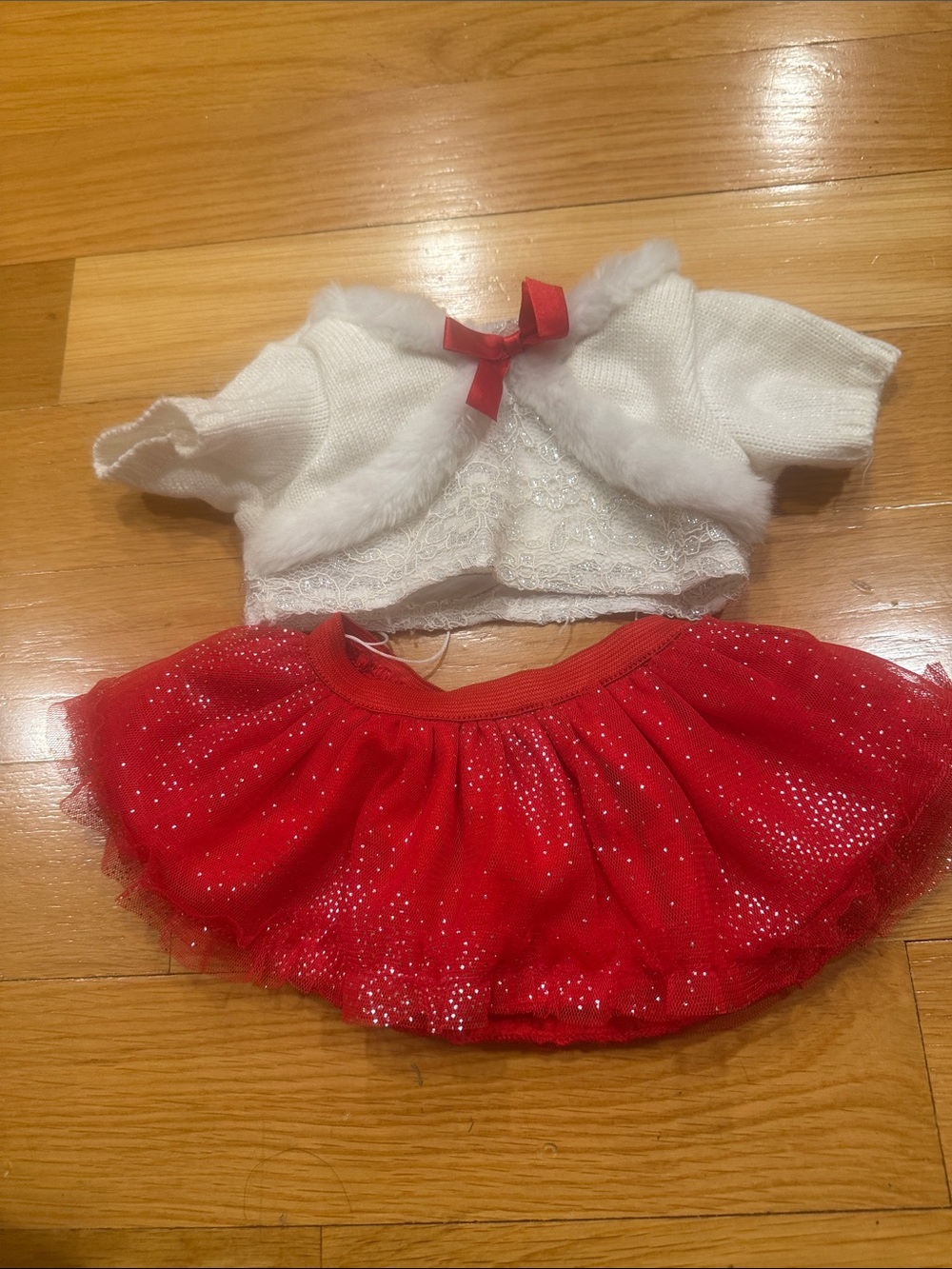 Bulid a bear white sweater with bow and a red sparkly tutu skirt .